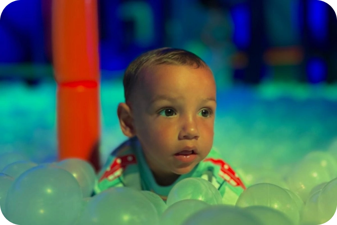niño jugando en piscina de bolas